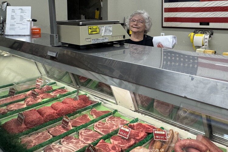 Employee weighs out meat for a customer at C. Roy Processing.