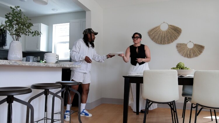 A couple stands in the dining area of a staged CLT home at 2080 Union, highlighting the space.