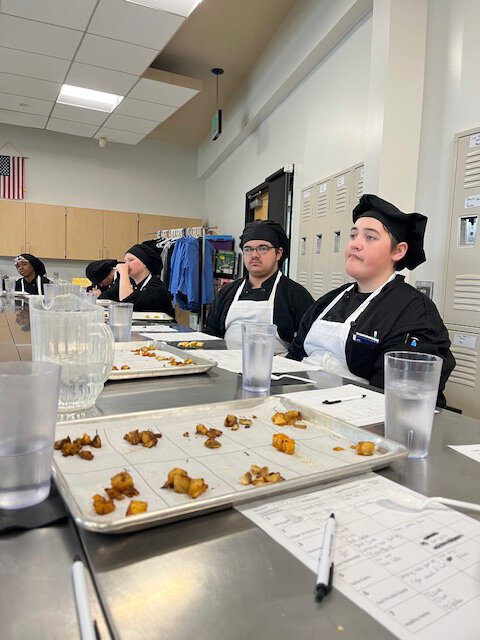 Students taste test different seasoning versions for roasted potatoes project. 