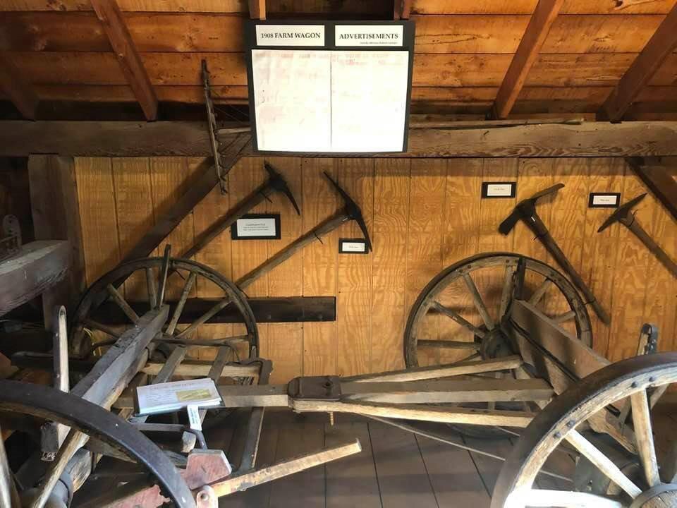Farm equipment and tools on display at a barn relocated to the Historic White Pine Village outside Ludington.