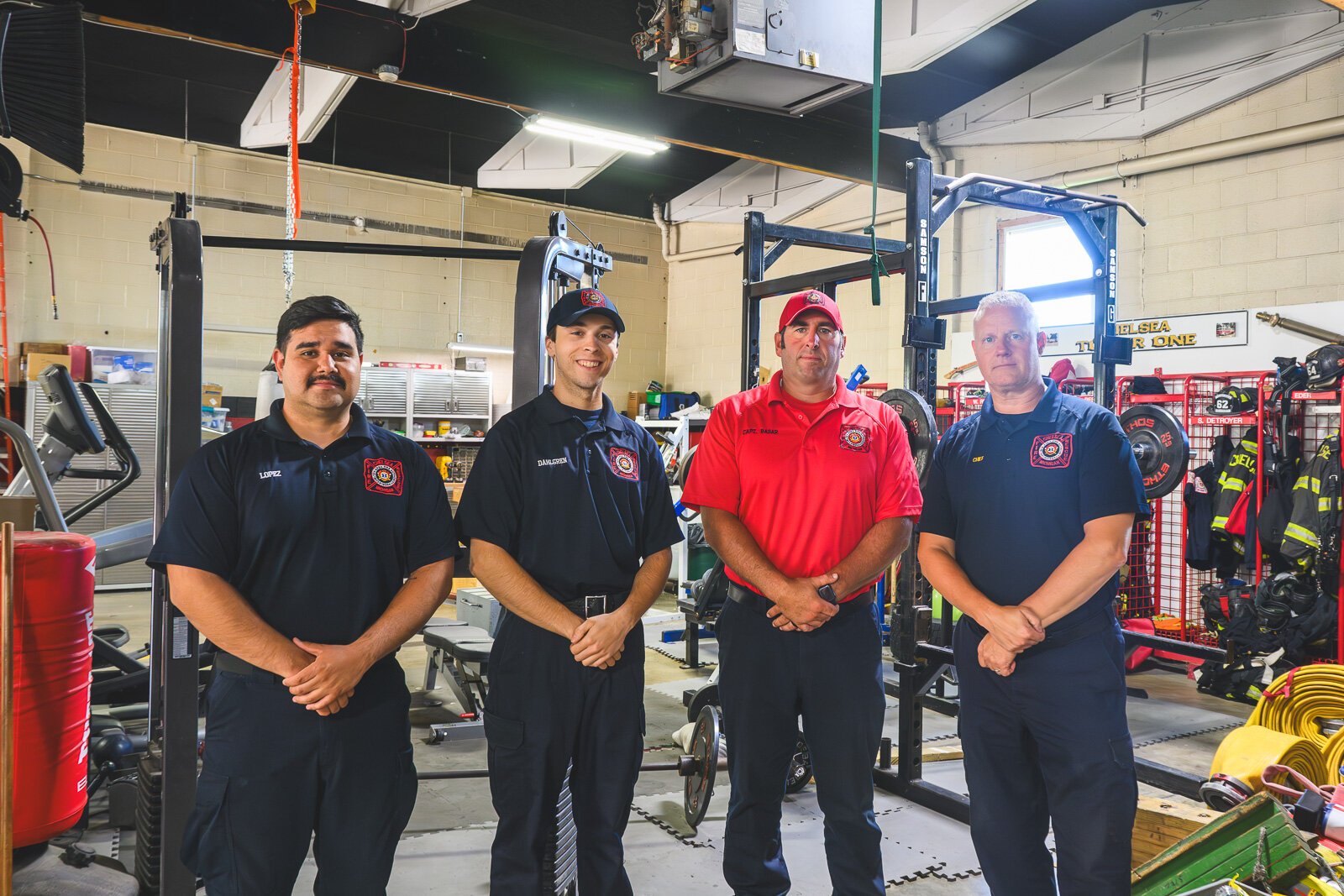 Chief Robert Arbini (right) with staff by the workout area in the bay of the Chelsea fire station.