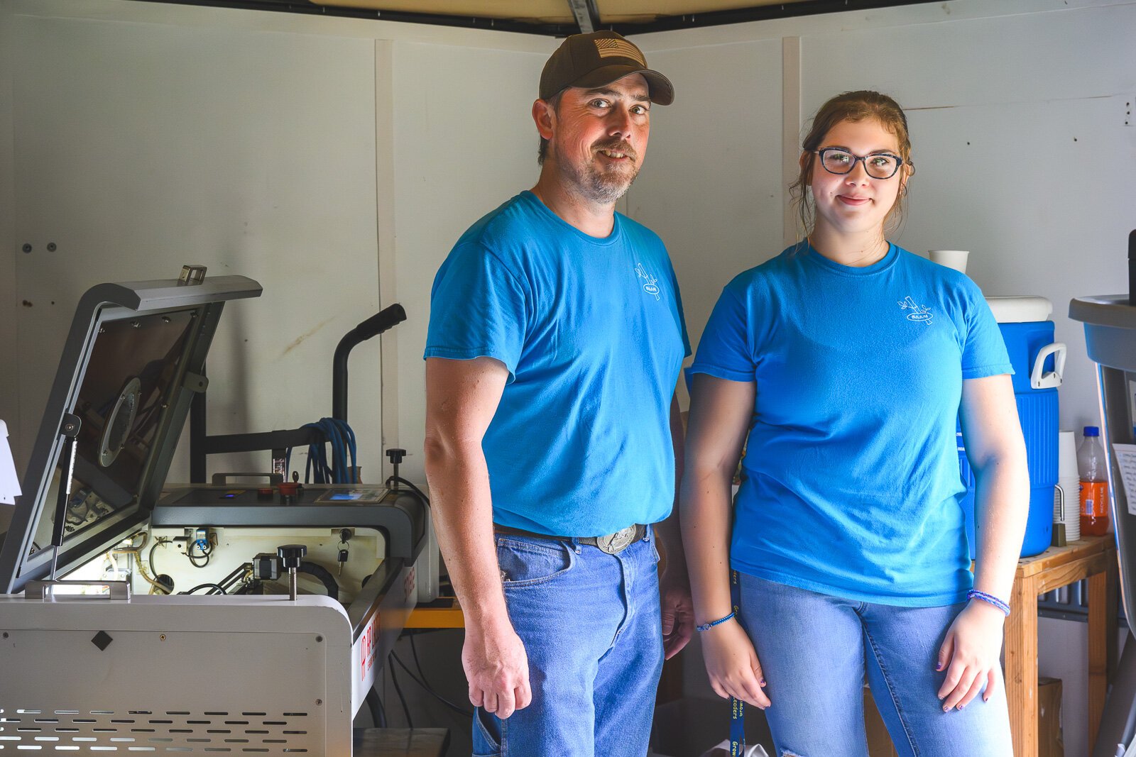 Joe Walsh and Annalies Walsh with a laser engraver in the Manchester Entrepreneurial STEM trailer.