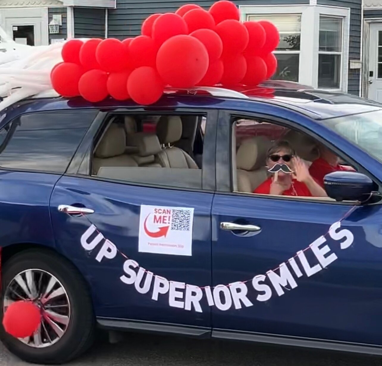 Lynda Gregorini showcases her school-based dental care nonprofit at a community parade.